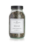 Jar of 'Revive' herbal tea blend with a label on a white background by spritzwellness