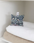 Floral-patterned pillow on a white surface with a neutral background