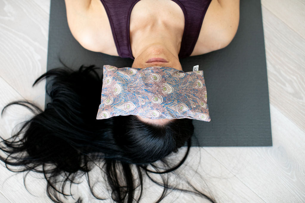 Savasana yoga pose with a Spritz Wellness aromatherapy eye pillow