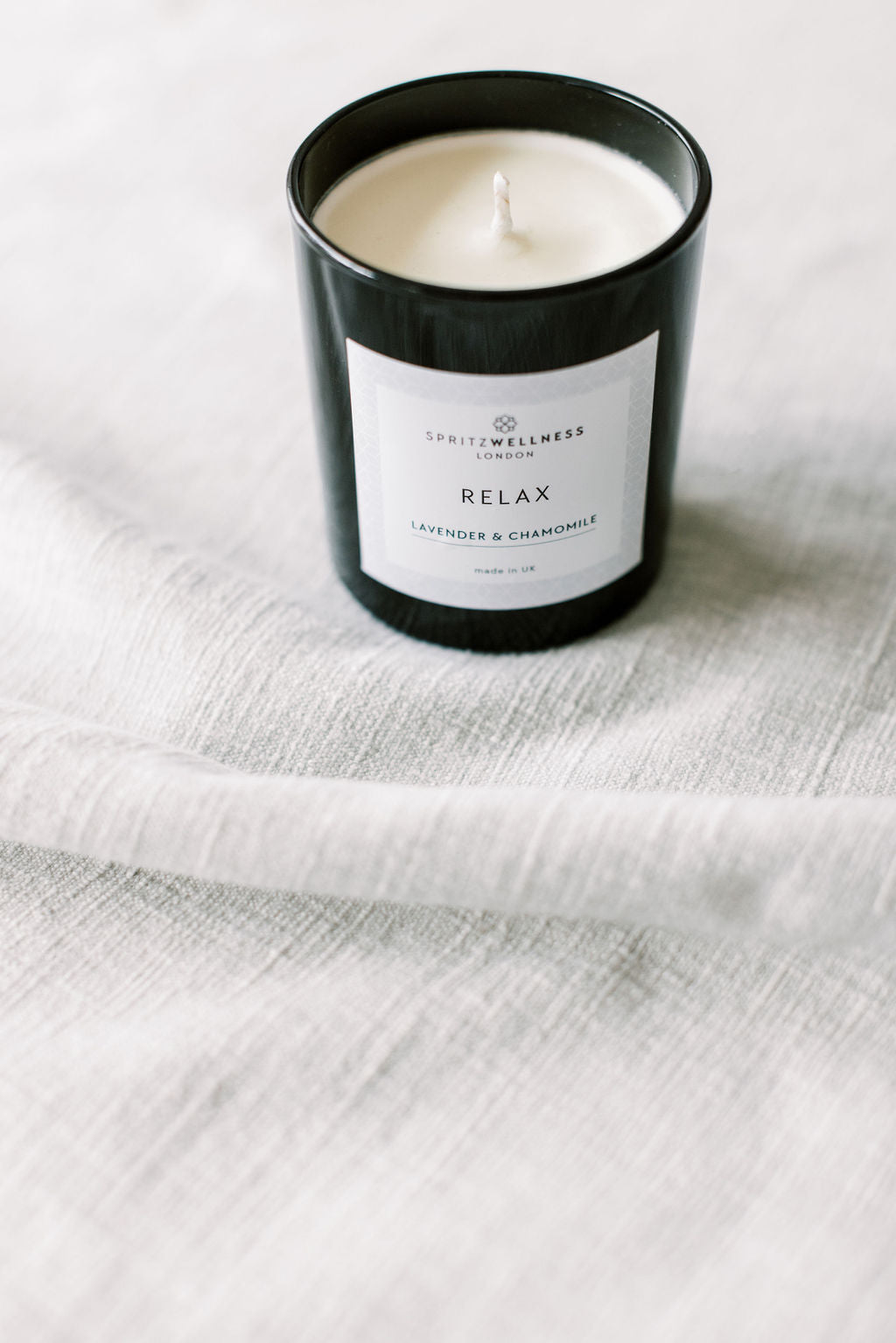 A calm evening setting with a Spritz Wellness candle for a wind-down breathing practice