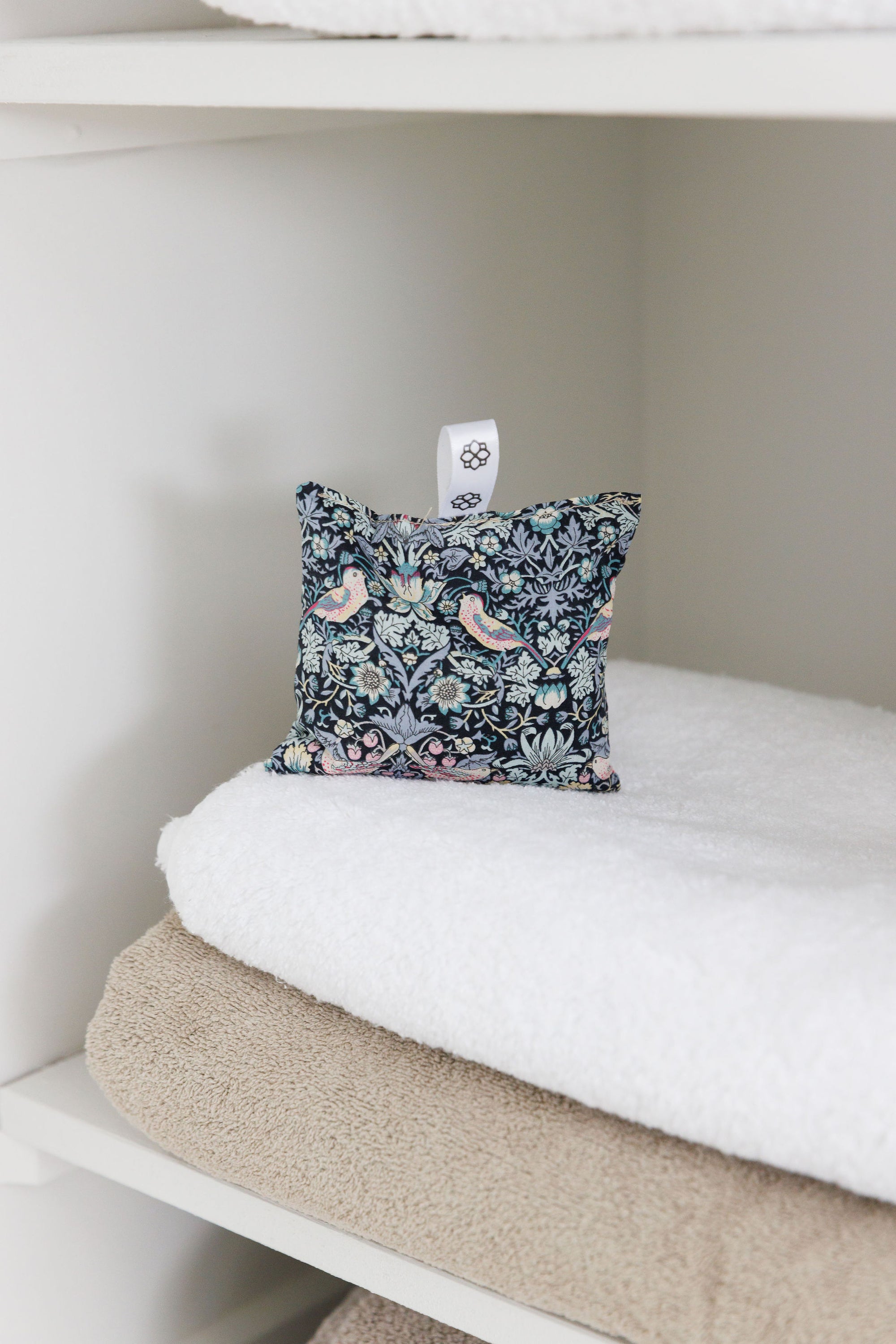 Floral-patterned pillow on a white surface with a neutral background
