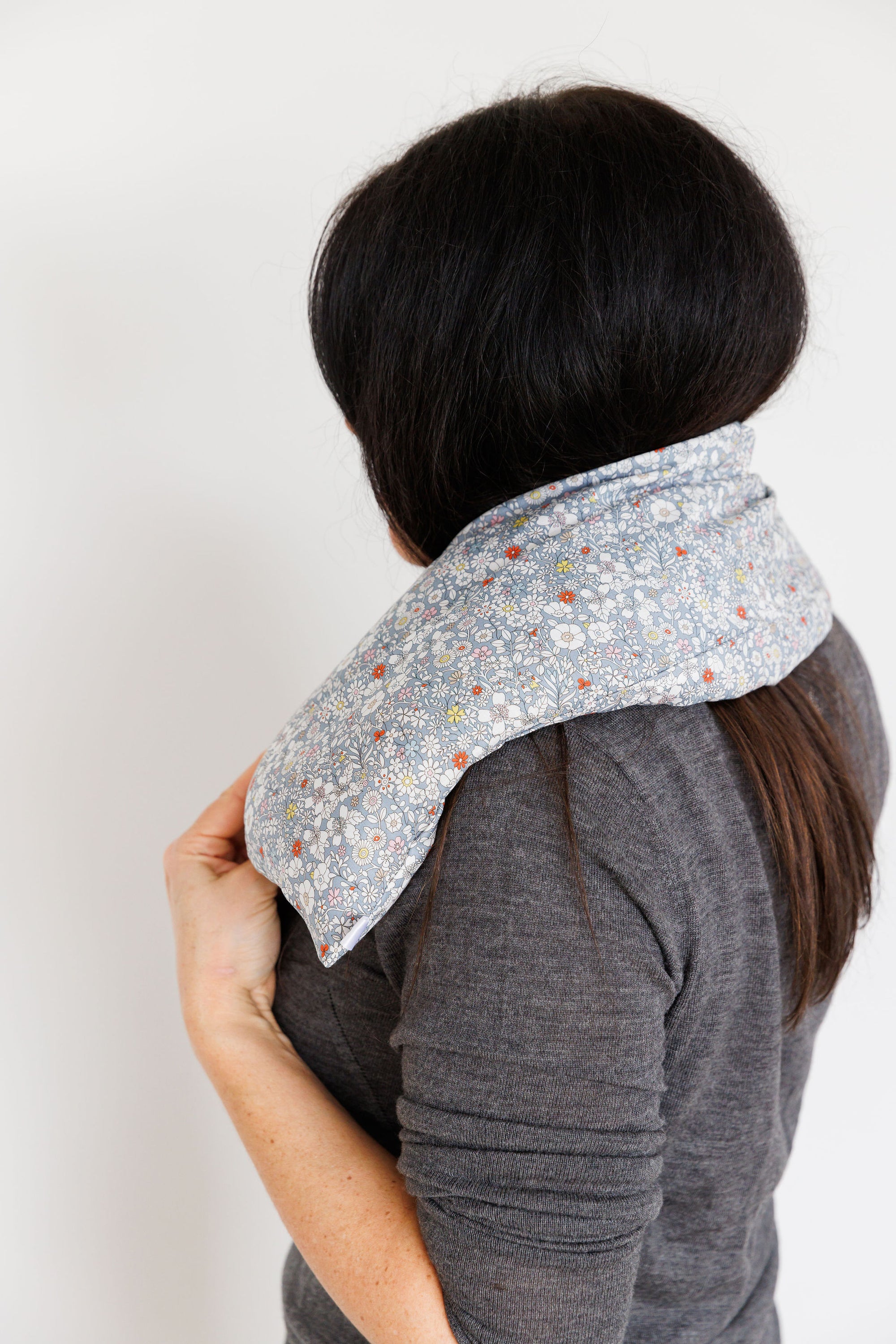 Aromatherapy wheat bag with a grey flowers Liberty Print design, made by Spritz Wellness, London.