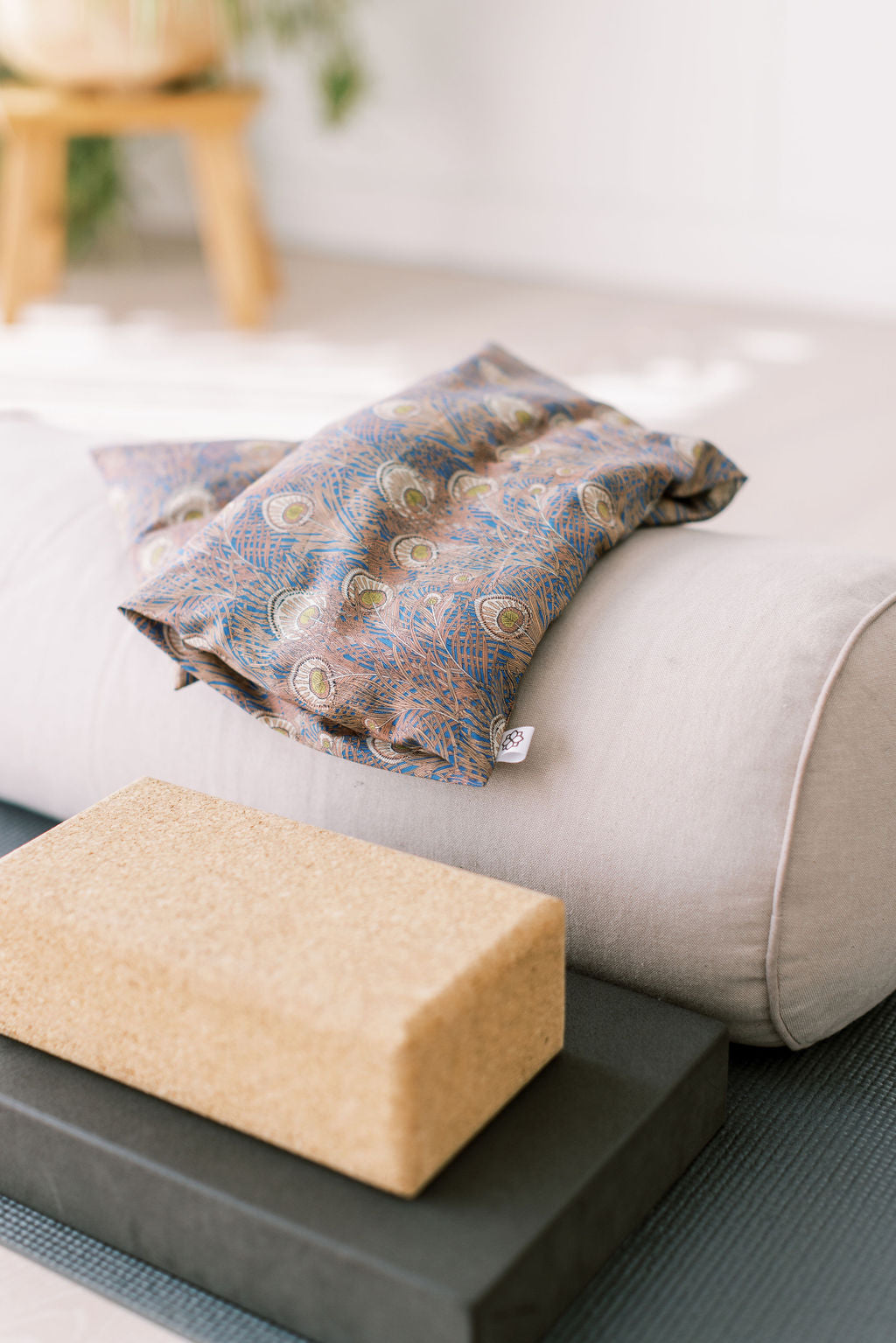 Lavender Wheat Bag, Liberty fabric, use heated or chilled, removable washable cover, with patterned cover and Spritz Wellness label on a yoga mat.