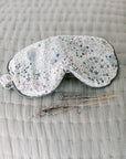 Sleep mask with star pattern on a textured surface with lavender buds